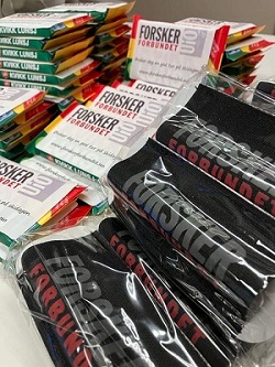 Photo of Kvikklunch chocolate and skistraps with the Forskerforbundet logo on them in black, grey and red