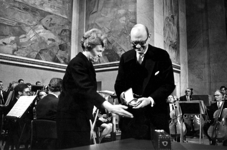 1969-10-10, ILO Director-General David A. Morse receives the 1969 Nobel Peace Prize on behalf of the ILO from Aase Lionaes, Chairman of the Nobel Committee of the Norwegian Parliament, in the Aula of the University of Oslo. ILO historical archives.
