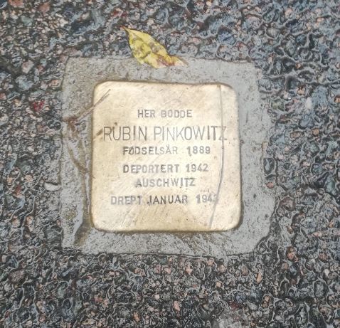 Bildebeskrivelse: En av snublesteinene som er plassert ut. Steinen har følgende tekst: Her bodde Rubin Pinkowitz. Fødselsår 1889. Deportert 1942 Auschwitz. Drept januar 1942.
