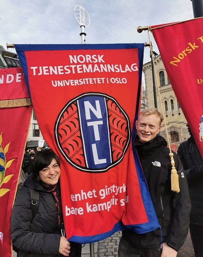 Bilde av NTL UiOs røde fane, med leder av foreninga til venstre og nestleder til høyre