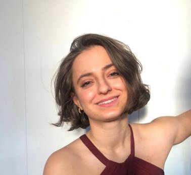 Lara Aref is elected president and smiling to the camera in front of a white background.